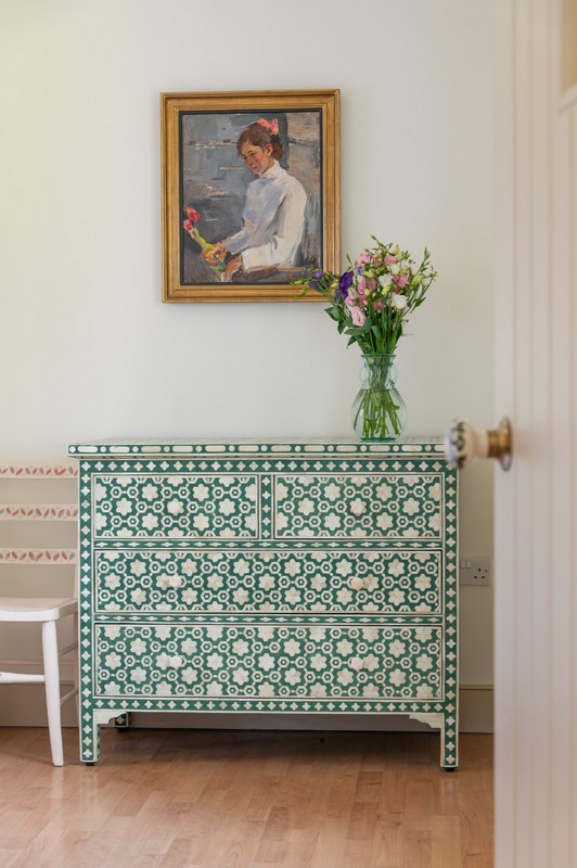 Ukrainian oil painting with mother of pearl green chest of drawers, flowers and hand-painted door handle and chair in calm but cheerful tones