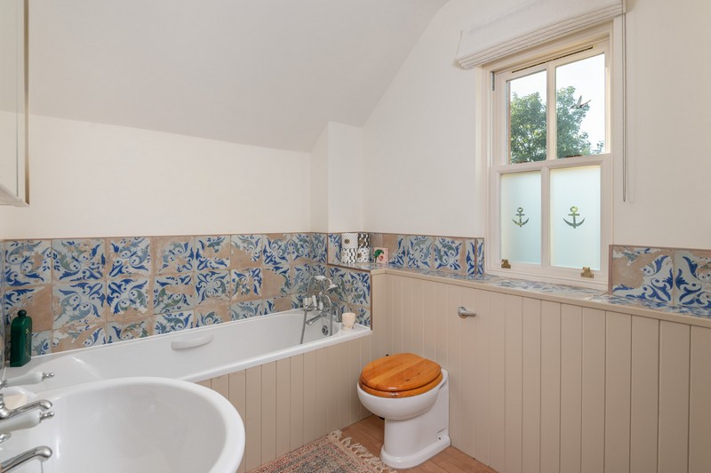 Upstairs Mediterranean-inspired bathroom with frosted window panes, loo and sink