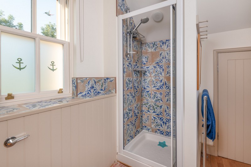 Upstairs mediterranean-inspired bathroom with frosted window panes, shower and heated tower rail