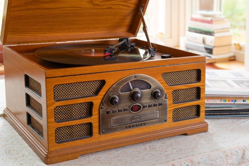 Record player with vinyl records and books in the background