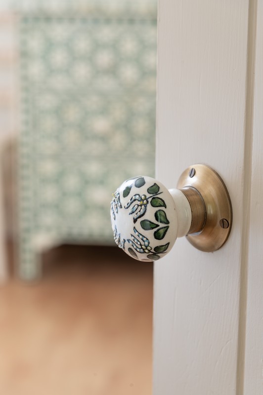 Decorative green and blue hand-painted door handle at entrance to main bedroom