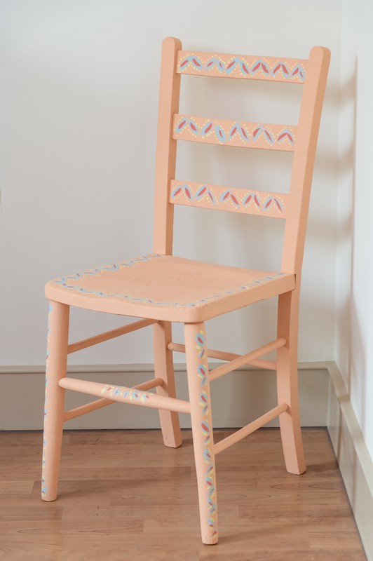 Hand painted coral, blue, pink and yellow chair in second bedroom