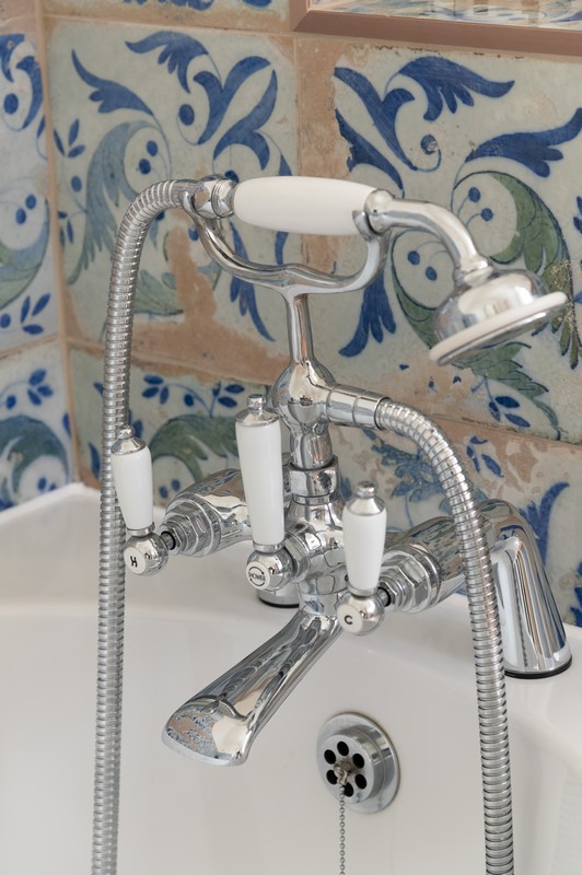 Mediterranean-inspired shabby chic bathroom tiles and shower/bath tap in upstairs bathroom